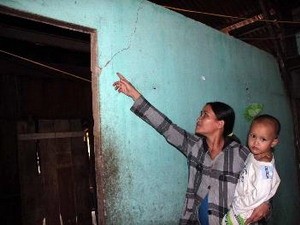 A woman points to cracks on her wall, caused by earthquakes, in Tra Tan Commune of Bac Tra My District in Quang Nam Province (Photo: VNA)