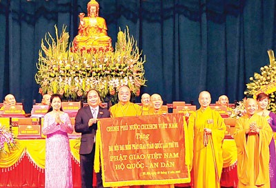 On behalf of the Party and government, Dep PM Phuc presents the Congress with a laudatory banner embroidered with the words ‘Vietnam Buddhism-protecting the nation and solace for people’ (Photo: Tran Luu)