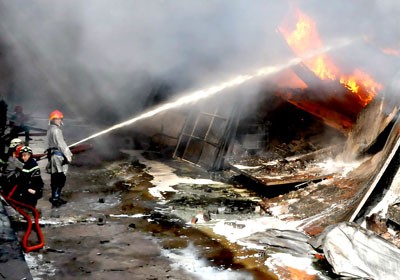 Fire fighters trying to douse the leaping flames in the warehouses in Thu Duc District (Photo: SGGP)