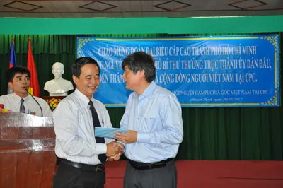 Phó Bí thư thường trực Thành ủy TPHCM Nguyễn Văn Đua (bên phải) trao tặng quà cho đại diện Tổng hội Người Việt Nam tại Campuchia.