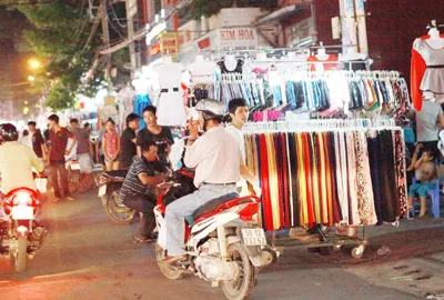 Đến hơn 18 giờ, các quầy bán quần áo di động cũng chiếm dụng lòng đường. Tiếp đến nào là giỏ, túi xách, dây nịt, vớ...