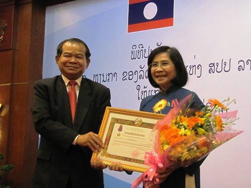 Soukan Mahalath, Mayor of Vientiane ( L ) presents Lao State's Isala Medal, second class to Nguyen Thi Thu Ha, Deputy Party Secretary (Source: Bao moi)