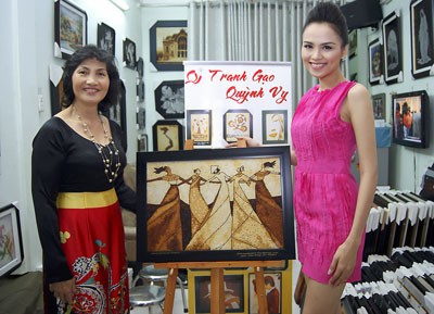 Diem Huong (R) and a Quynh Vy Company representative with the rice picture (Photo: SGGP)