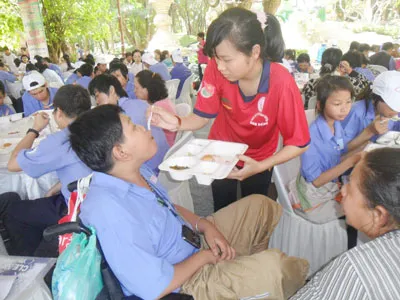 Tình nguyện viên đang chăm sóc người khuyết tật tại hội trại