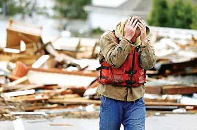 Một người dân ở bang New Jersey, Mỹ trước ngôi nhà bị tàn phá.