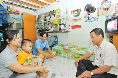 Một chủ nhà trọ ở quận Bình Tân thăm hỏi gia đình công nhân đang trọ. Ảnh: VIỆT DŨNG