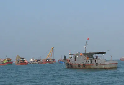 Tàu Hải đội hai bọc bên ngoài để ngư dân trục vớt Các tàu đánh cá xếp thành hàng dài để tạo độ lặng cho công tác trục vớt Thợ lặn được thuê từ Hà Tĩnh đang tiến hành lặn ráp cáp trục vớt