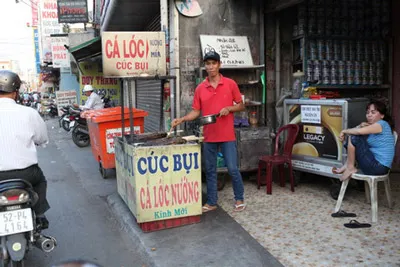 Cá lóc nướng phơi bày ngay trên vỉa hè không có khay che chắn bụi trên đường Tân Kỳ Tân Quý, quận Tân Phú.
