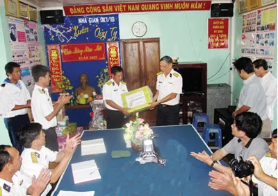 Thượng tá Phạm Đăng Dinh (Trưởng đoàn chúc tết tàu HQ 636 đứng bên phải) trao quà cho cán bộ, chiến sĩ nhà giàn DK1/10.