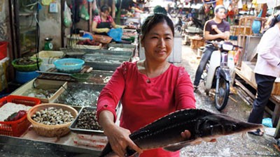 A trader at Thanh Cong Market in Hanoi displays a Chinese sturgeon fish