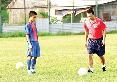 HLV Nguyễn Mạnh Cường đang thị phạm các thi sinh sút bóng