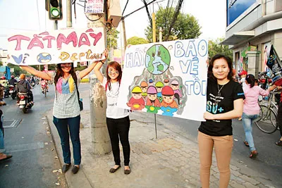 Bất chấp nắng nóng lên đến gần 40°C, các tình nguyện viên vẫn đứng tại những ngã tư vận động người đi đường tắt máy xe khi tín hiệu đèn đỏ.