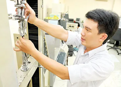 Kỹ sư Nguyễn Vũ Nhân nghiên cứu cải tiến bọc dây cáp chịu lực bằng cao su lõi thép. Ảnh: VIỆT DŨNG