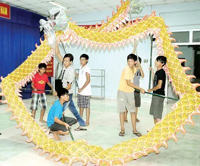 Các thanh thiếu niên đội Lân - Sư - Rồng Long Việt, phường 14, quận 8 tập luyện múa rồng. Ảnh: PHẠM KIM NGÂN