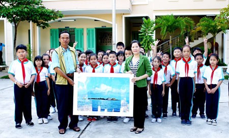 Photographer Tran Minh Ngoc gifts photo to a school in Khanh Hoa Province(Photo:SGGP)