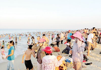 Residents flock to the beach to escape the scorching heat in the central region (Photo: SGGP)