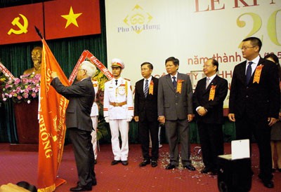 City's Chairman Le Hoang Quan sticked the medal onto the company's traditional flag in the meadl awarding ceremony on May 18, 2013.