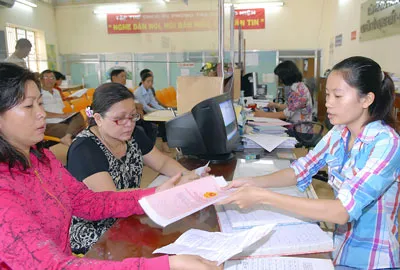 Nhân viên Văn phòng đăng ký quyền sử dụng đất quận 6 TPHCM giải quyết hồ sơ cho người dân. Ảnh: KIM NGÂN
