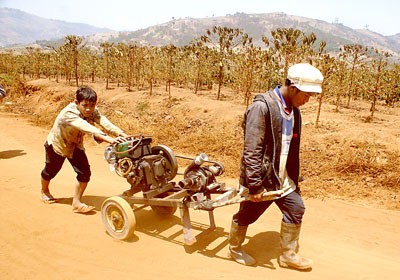 Farmers carry a water pump to irrigate coffee plants in Lam Dong Province in the Central Highlands (Photo: SGGP)