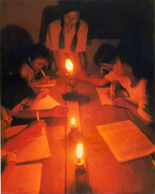 Dạy chữ học sinh vùng xa trong ánh đèn dầu. Ảnh: HOÀI NAM