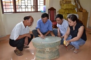 Archaeologists discuss the newly-found bronze drum from northern province of Bac Kan.