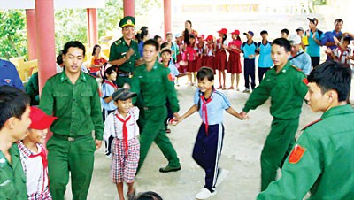 Soldiers play with students of Long Hai Commune. (Photo: SGGP)