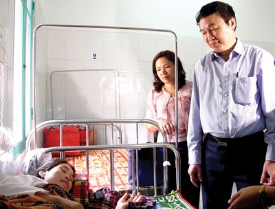 Dr Nguyen Tran Hien visits a mother whose baby died after vaccine in Huong Hoa District in the central province of Quang Tri (Photo : SGGP)