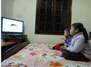 Two children watching a cartoon on TV. Vietnam plans to have around 110-130 Television Channels by 2015
