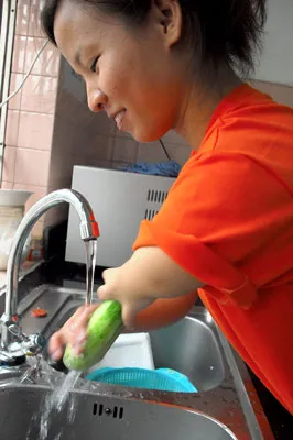 Em Minh Tâm, dù đôi tay bị dị tật nhưng em vẫn rửa rau quả rất điệu nghệ.