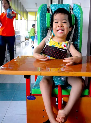 Bé Phạm Xuân Mai, không đi được nhưng vẫn tươi cười vui chơi với bạn.
