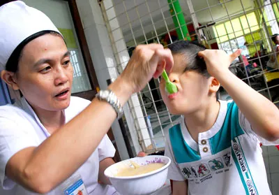 Y sĩ Phạm Thị Kim Vân chăm sóc bé Trần Huỳnh Thương Sinh bị khiếm thị.