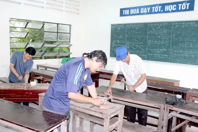 Giáo viên Trường THPT Long Mỹ (Hậu Giang) sửa lại bàn ghế cũ để có đủ bàn ghế cho học sinh ngồi. Ảnh: HUY PHONG