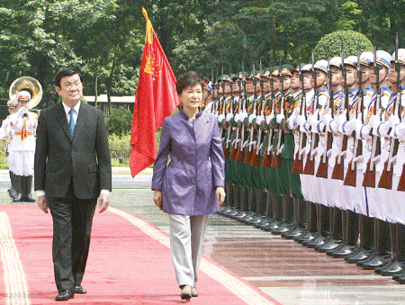 President Truong Tan Sang and Republic of Korea President Park Geun-hye review a Guard of Honour in Ha Noi yesterday -VNS