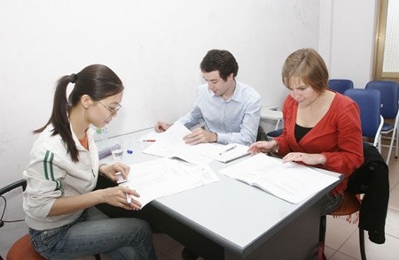 Vietnamese and foreign teachers at a Hanoi-based English Center prepare their lesson plans. According to a new decree on the hiring of overseas employees, foreign workers without work permits in Viet Nam will be deported (Photo: VNS )