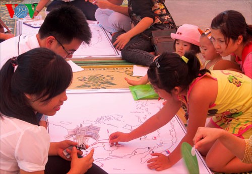 Children play folk games at the event (Photo: VOV) Visitors enjoy Malaysian food at the event (Photo: VOV) Laotian girls perform their traditional dances at the event (Photo: VOV)