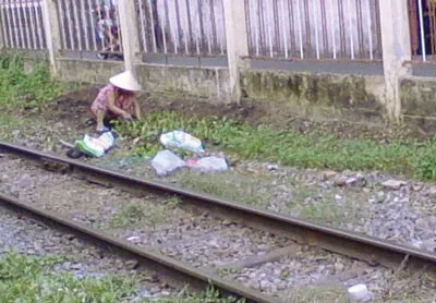 Người dân vô tư ngồi trồng rau gần đường ray (giao lộ Nguyễn Trọng Tuyển, quận Phú Nhuận).