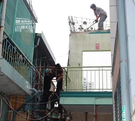 Nhân viên Công ty TNHH MTV Dịch vụ công ích quận giúp dân tháo dỡ phần còn lại căn nhà 283/30/27 để tránh nguy hiểm.