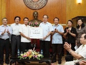 VFF President Nguyen Thien Nhan receives the money donated by Vietnam News Agency staff (Source: VNA)