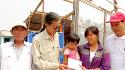 A representative of SGGP newspaper gives money to residents in Hai Ninh Commune in Quang Binh Province (Photo: SGGP)