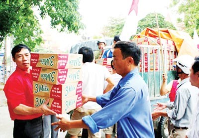 Delivering instant noodle to storm victims in Hoang Mai, Nghe An Province. (Photo: SGGP)