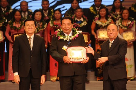 President Truong Tan Sang (L) and Nguyen Quoc Cuong (R), chairman of Farmer Association give merit certificate to a farmer (Photo: Hanoimoi)