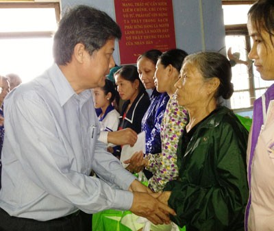 Mr. Nguyen Van Dua (L) offers gifts to poor families in Quang Son Commune (Photo:SGGP)