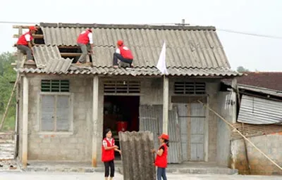 Tình nguyện viên Chữ thập đỏ tỉnh Quảng Trị giúp người dân lợp lại nhà bị tốc mái do bão.