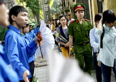 Các sinh viên tình nguyện quạt mát cho dòng người đến viếng Đại tướng