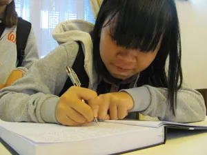 Em Phạm Thị Huyền, sinh viên năm 2, Trường Đại học Luật TPHCM ghi sổ tang.