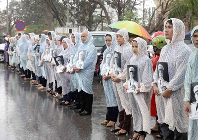 Các đoàn viên, thanh niên cầm di ảnh Đại tướng đứng dưới mưa, trước UBND tỉnh Quảng Bình chờ vào viếng Đại tướng.