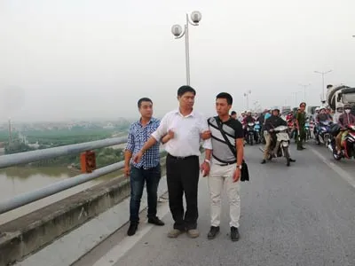 Bác sĩ Nguyễn Mạnh Tường (áo trắng) tại cầu Thanh Trì để công an dựng lại hiện trường vụ án. Ảnh: Quốc Khánh.