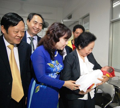 Vice president Nguyen Thi Doan carries the lucky baby girl (Photo: SGGP)