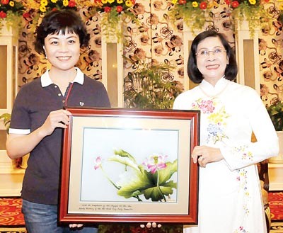 Nguyen Thi Thu Ha, Deputy Secretary of the HCMC Party Committee (R) offers a gift to writer Tie Ning, Chairwoman of the Chinese Writers' Association.