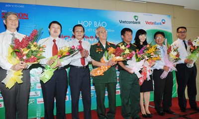 Nguyen Tan Phong, SGGP Editor-in-Chief (third from L), offers flowers to sponsors. (Photo: sggp)